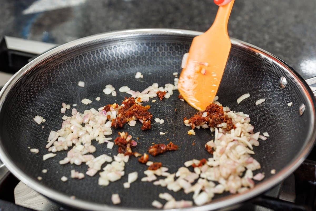 Sauteing onion and sun-dried tomatoes.
