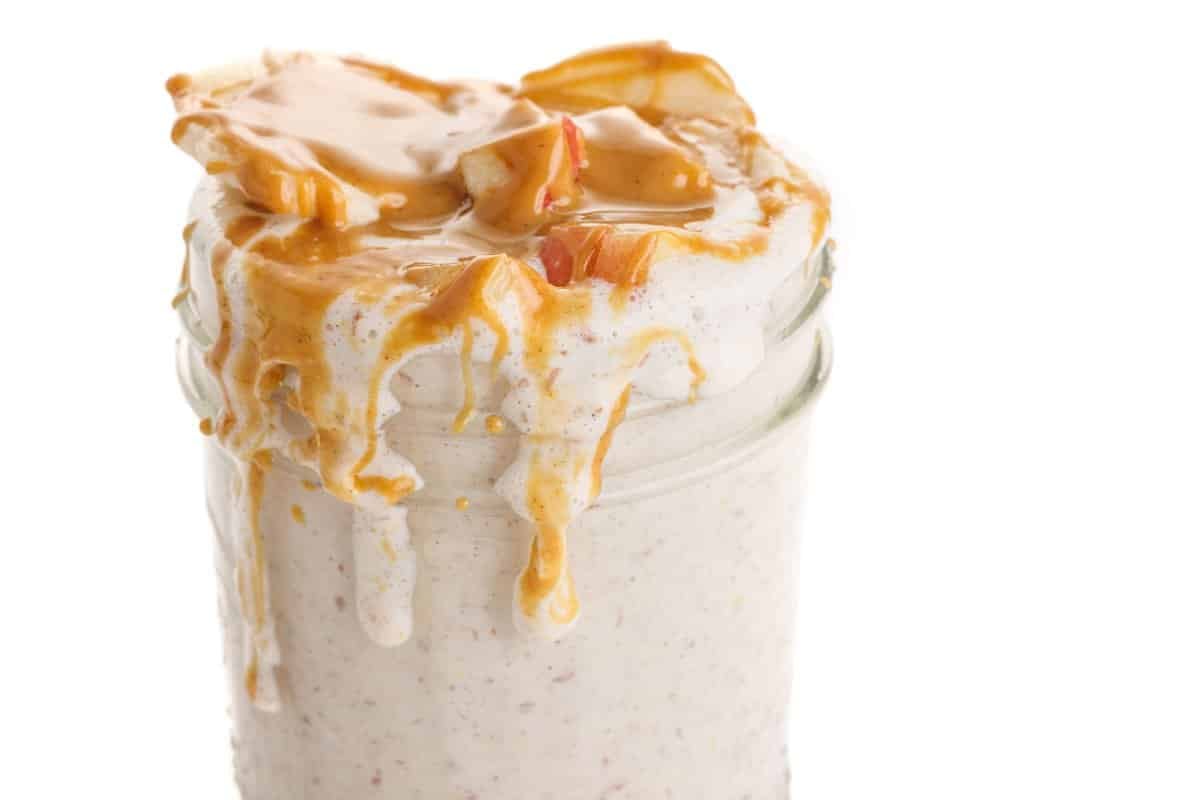 Overnight steel cut oats in a mason jar topped with peanut butter, one of 20 cozy oatmeal recipes.