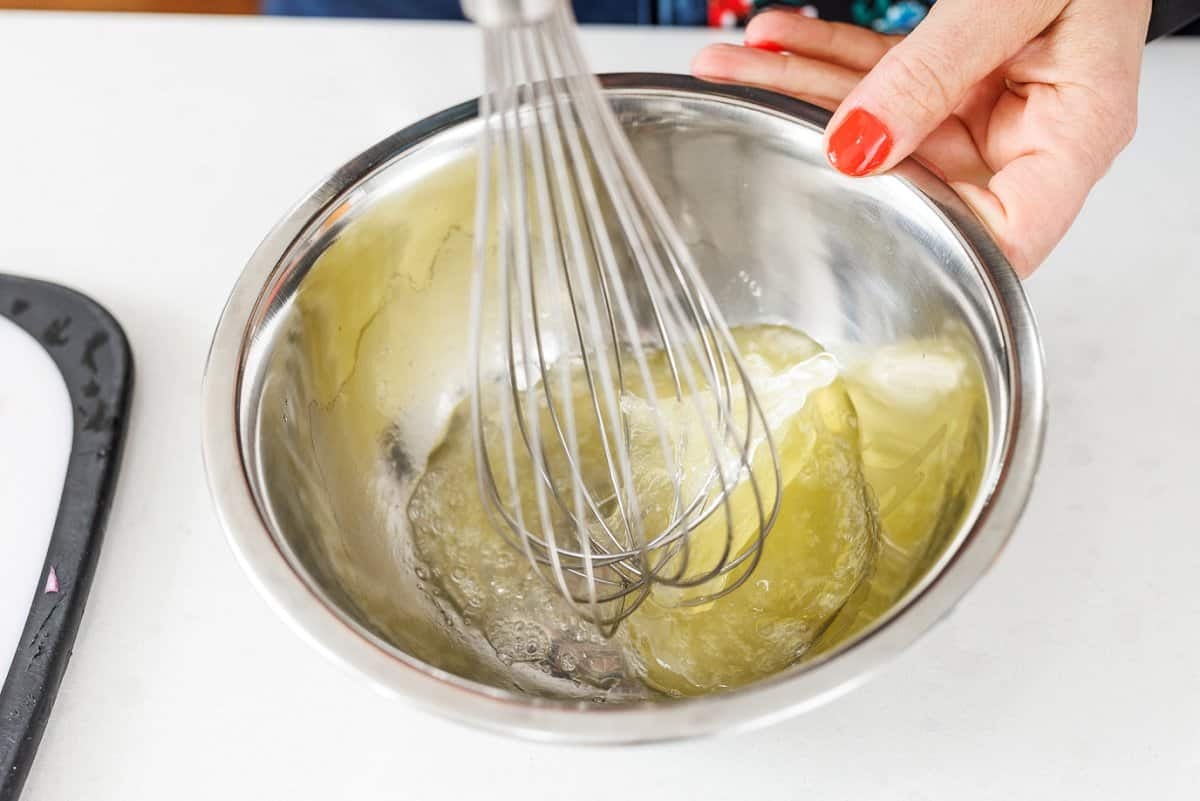 Whisking egg whites in a metal bowl.