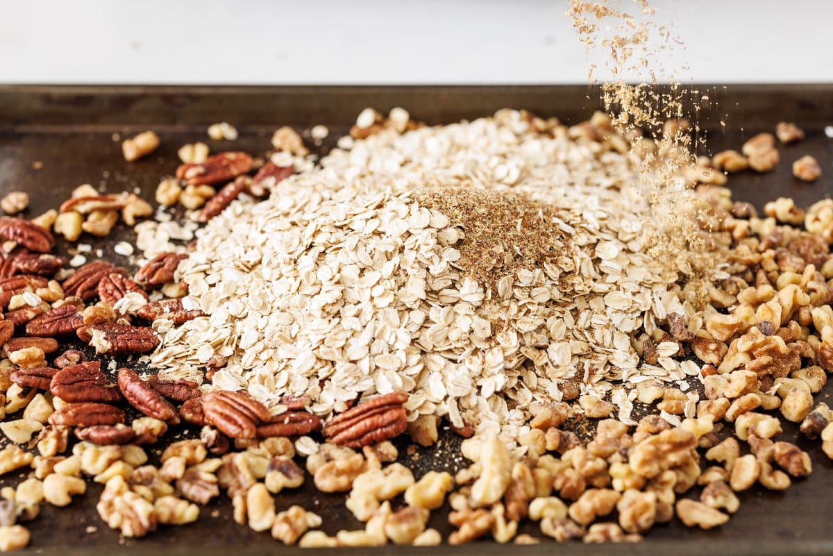 Oats, flax, and nuts on a baking sheet.