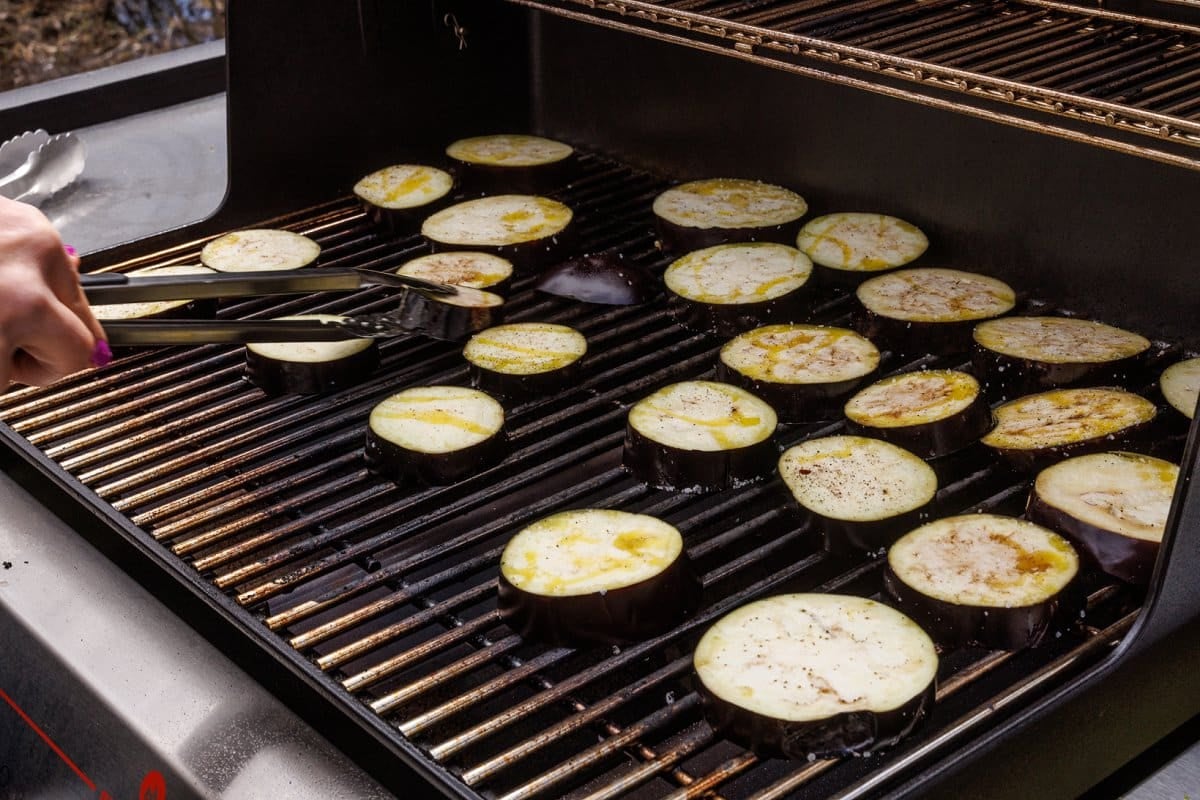 Eggplant slices grilling on the grill.