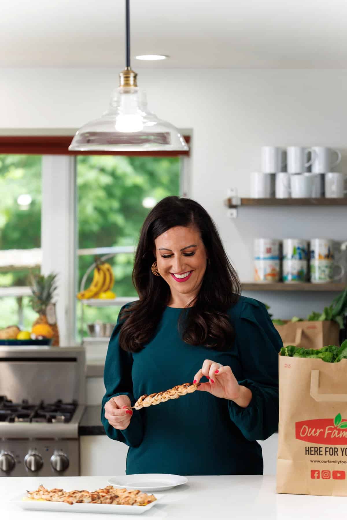 Liz eating grilled shrimp shawarma skewers.