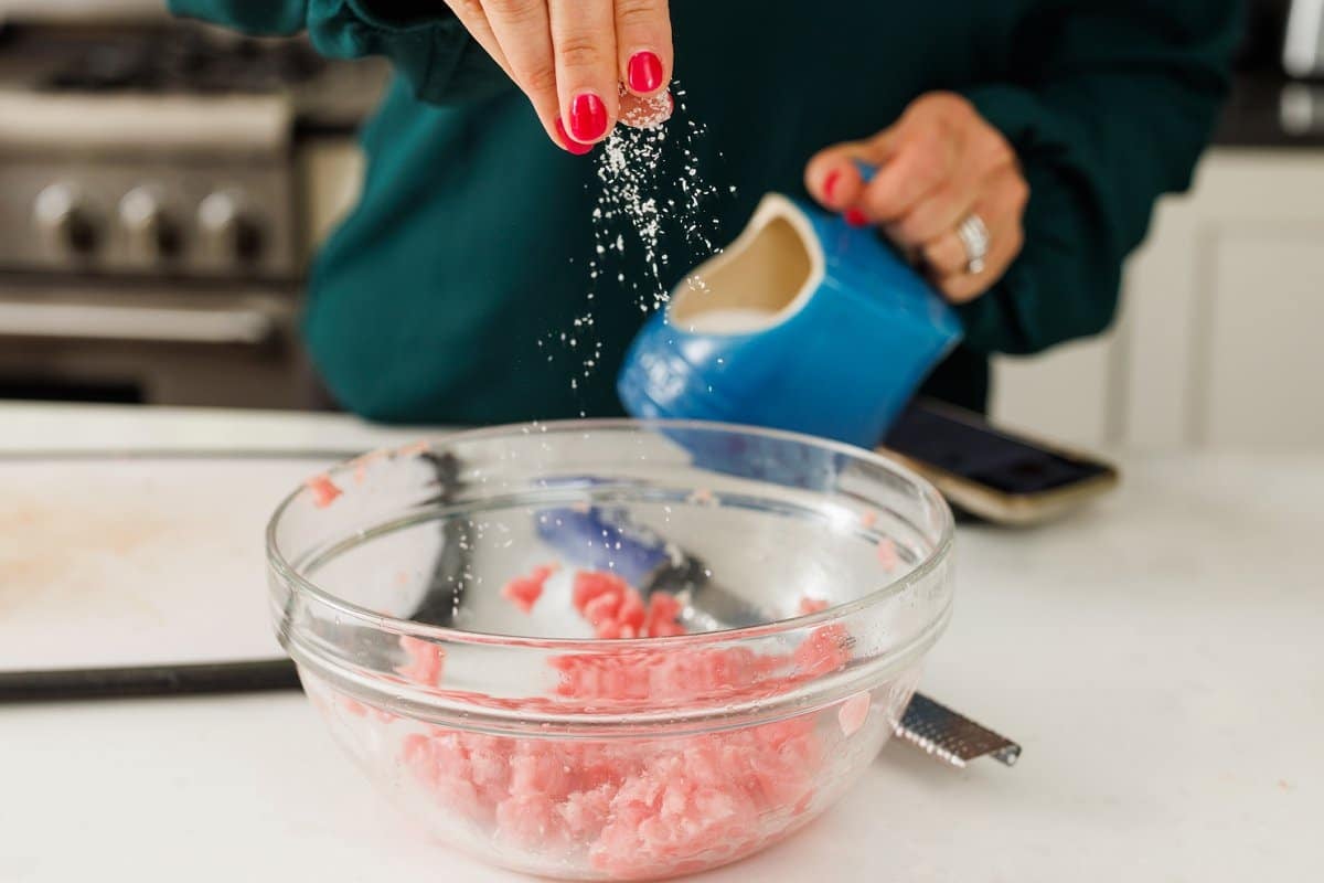 Salting ahi tuna in a bowl.