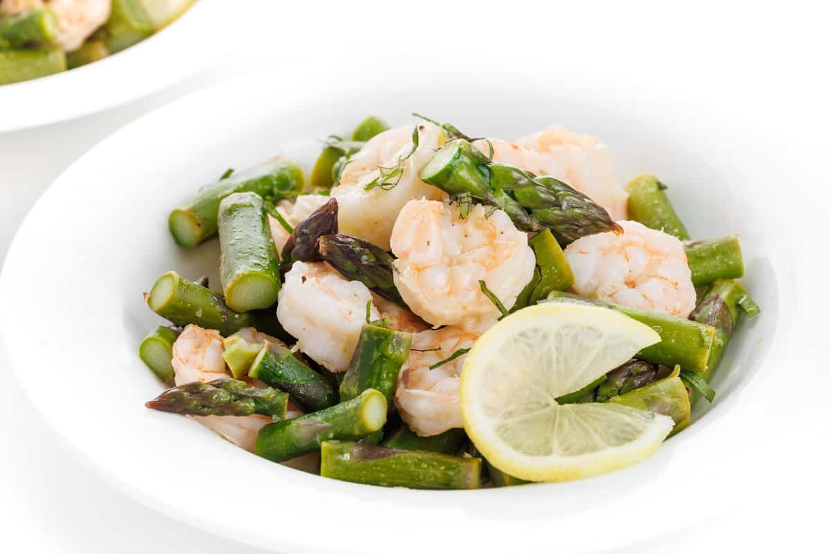 Shrimp and asparagus pouches in bowl with lemon garlic butter.