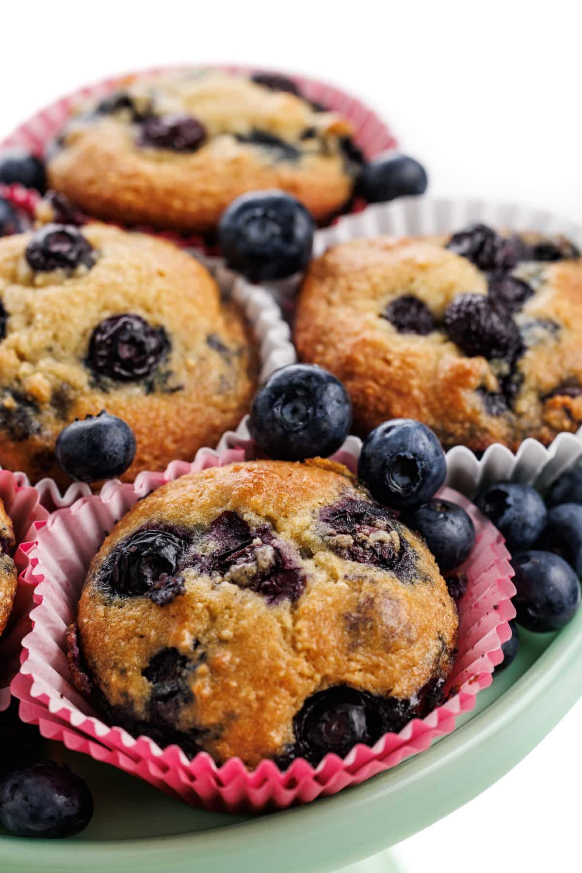 Almond flour blueberry muffins. on a plate with fresh blueberries.