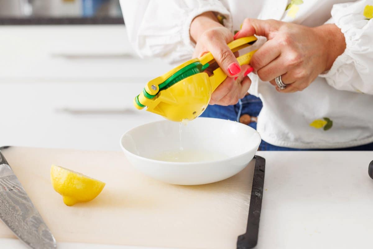 Liz squeezing lemon juice into a bowl.