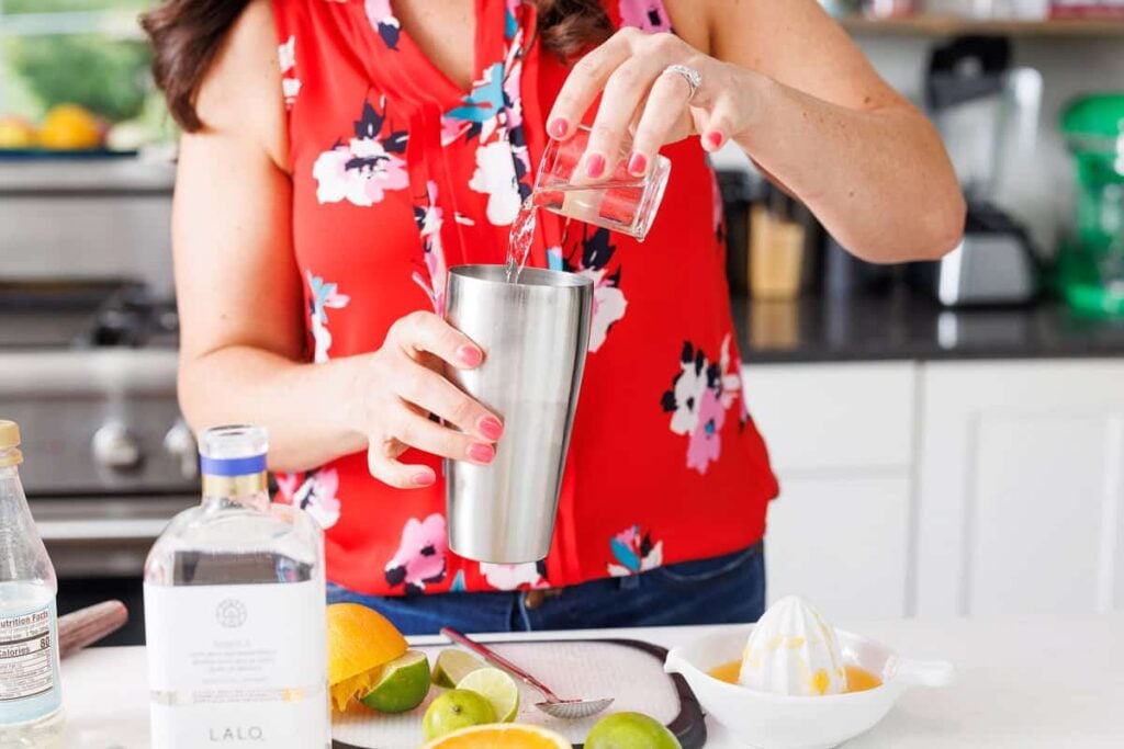 Liz pouring tequila into cocktail shaker.