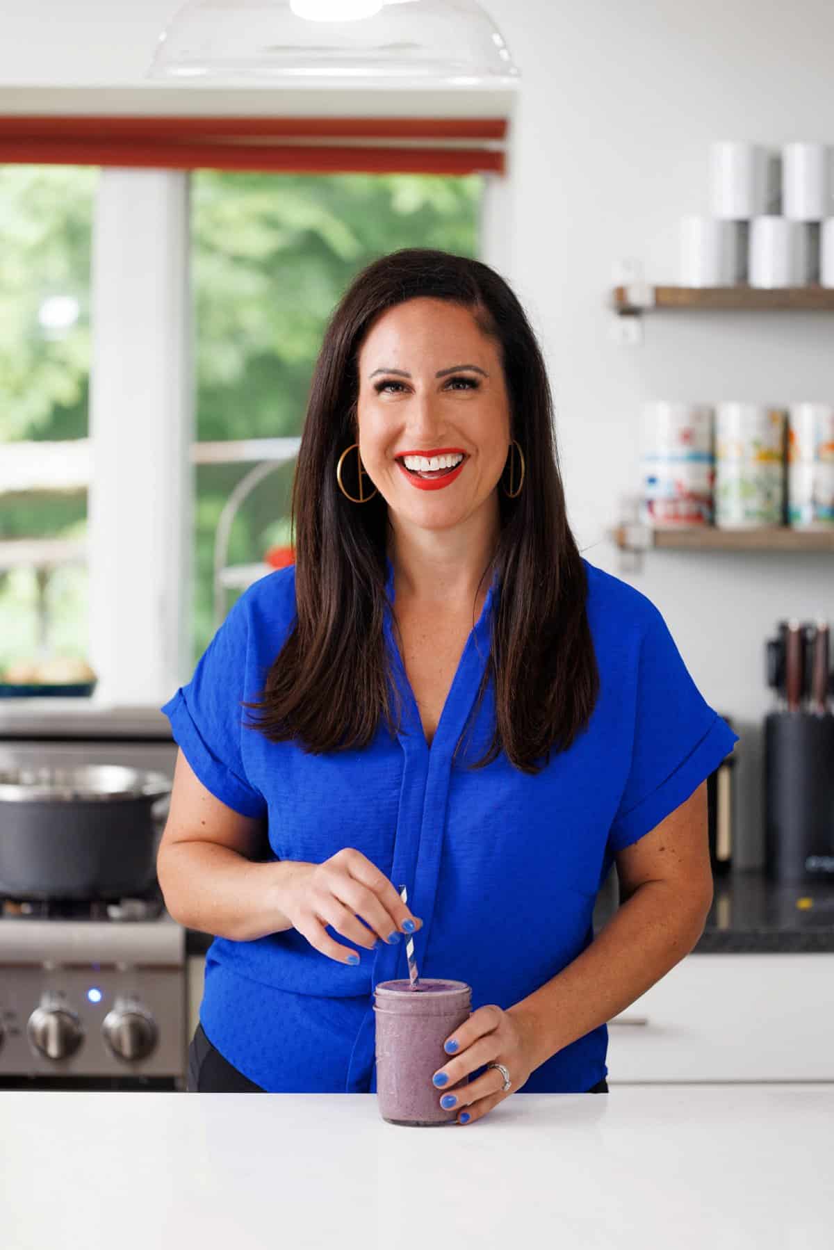 Liz drinking a blueberry vanilla protein smoothie.