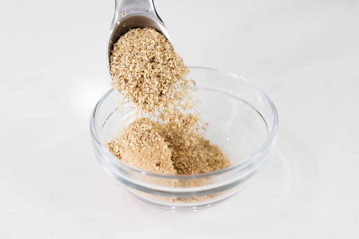 Pouring brown sugar into a small glass bowl.