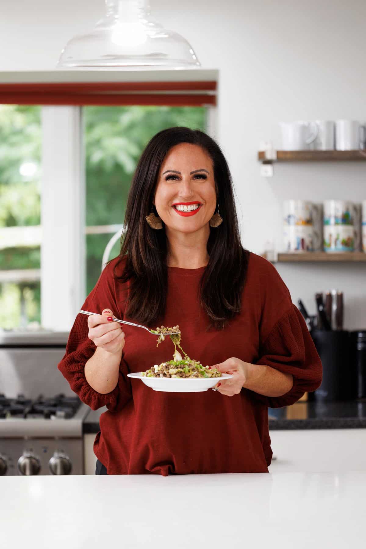 Liz eating ground beef and cabbage stir-fry.