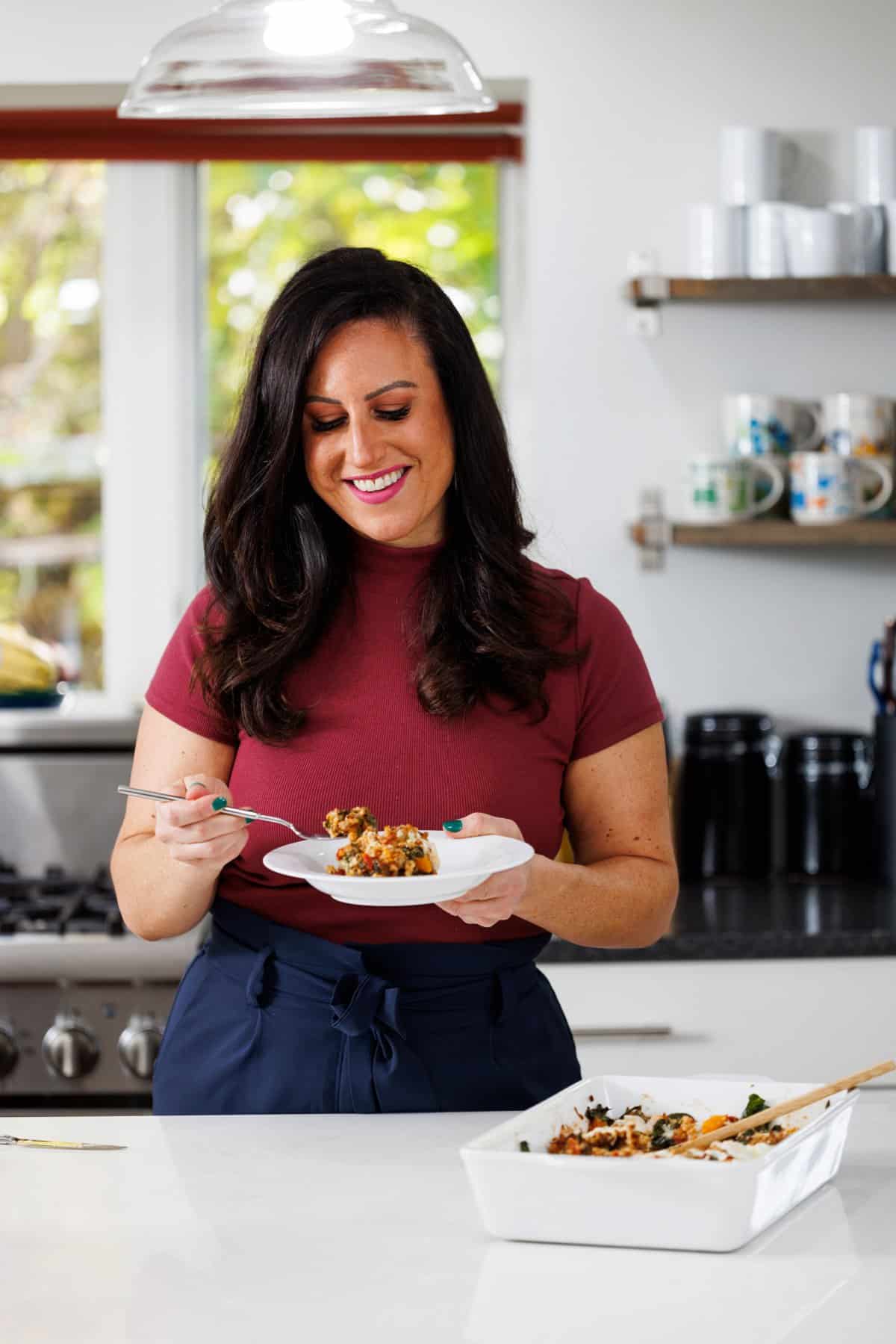 Liz eating Italian sausage and butternut squash farro bake.
