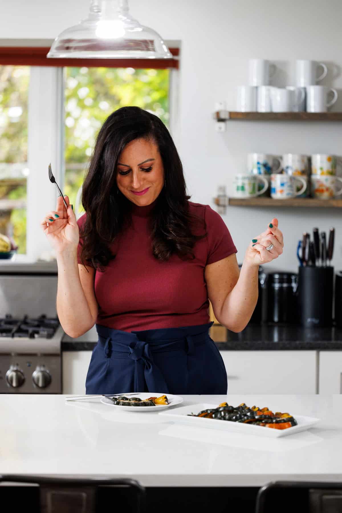 Liz eating roasted acorn squash with tahini sauce.