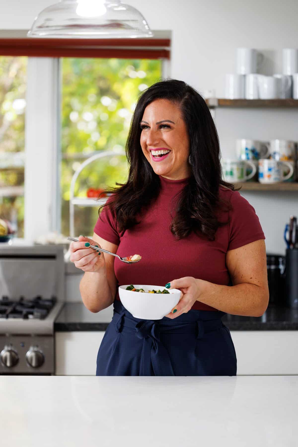 Liz eating chicken soup with delicata squash and kale.