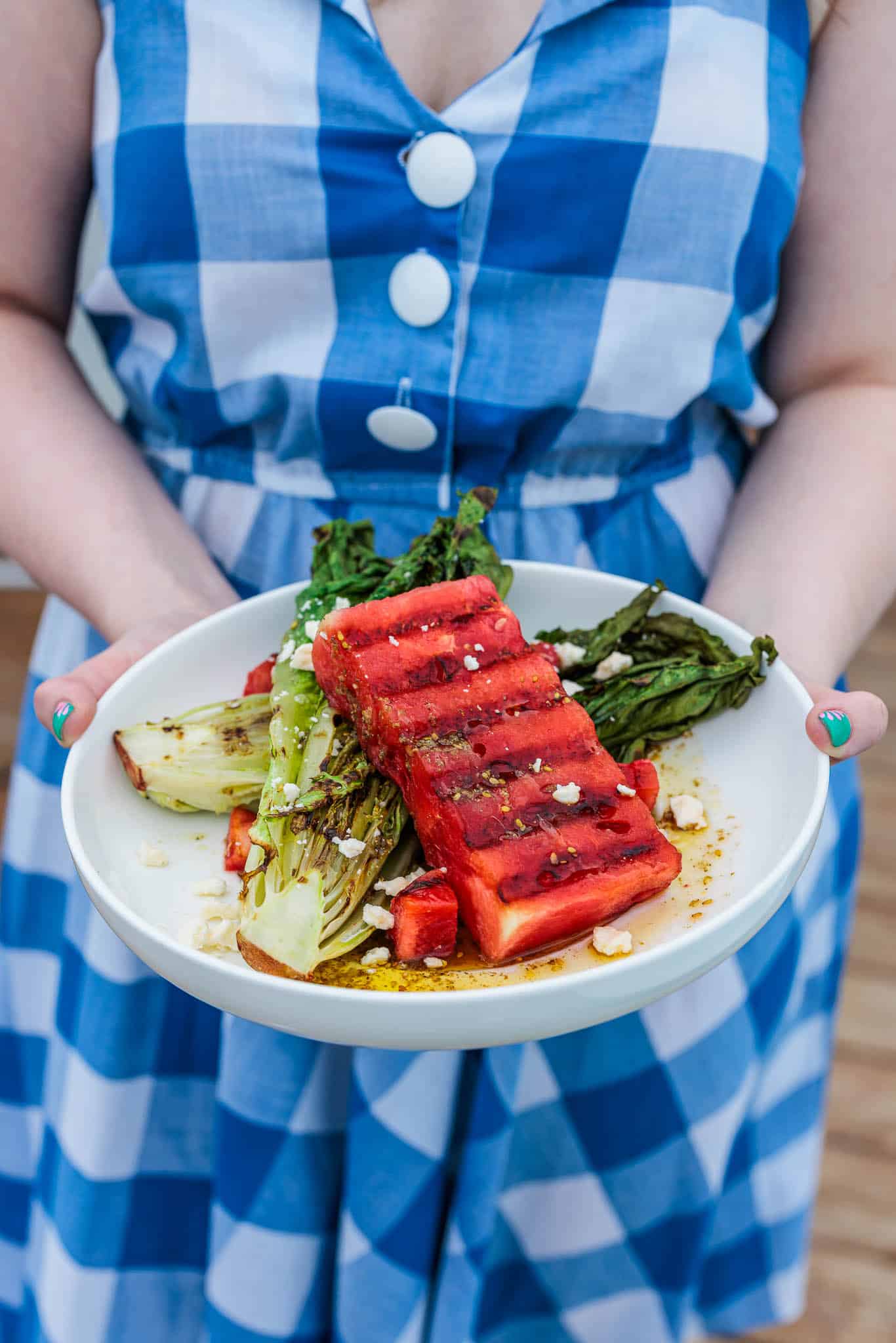 Holding a grilled watermelon and feta salad.