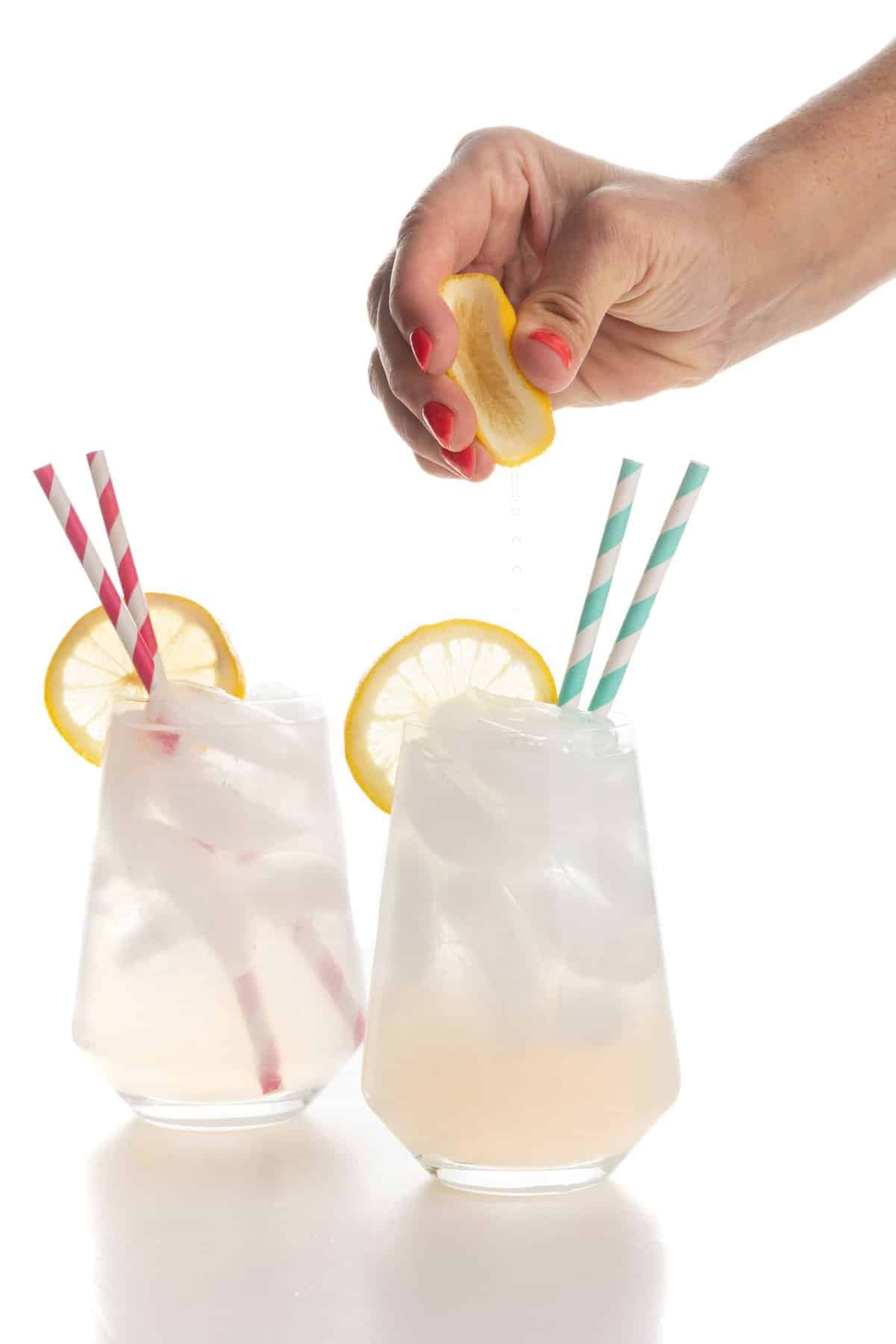 Garnishing blood orange lemonade gin spritz with lemon juice.