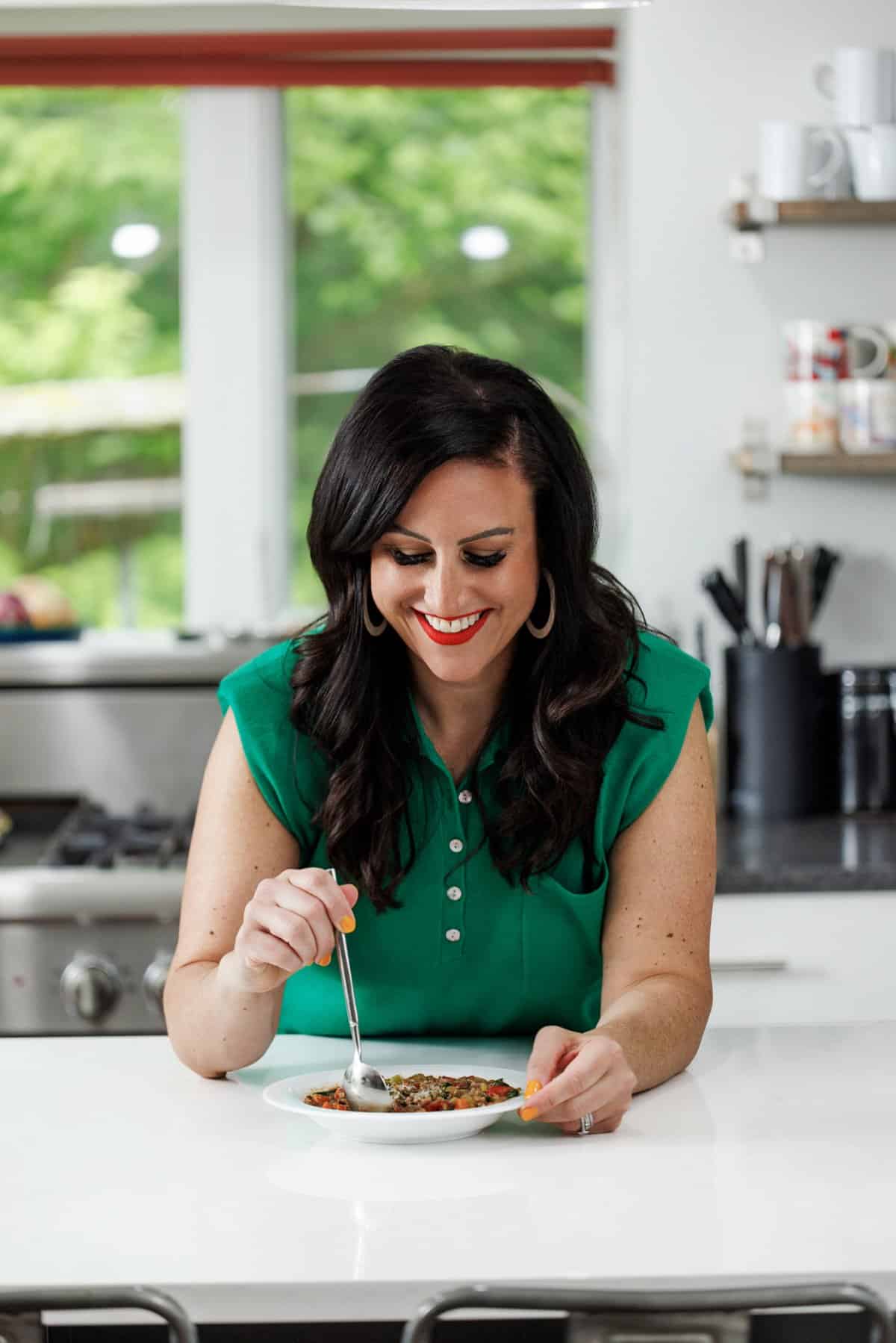 Liz eating lentil soup with sausage and spinach.