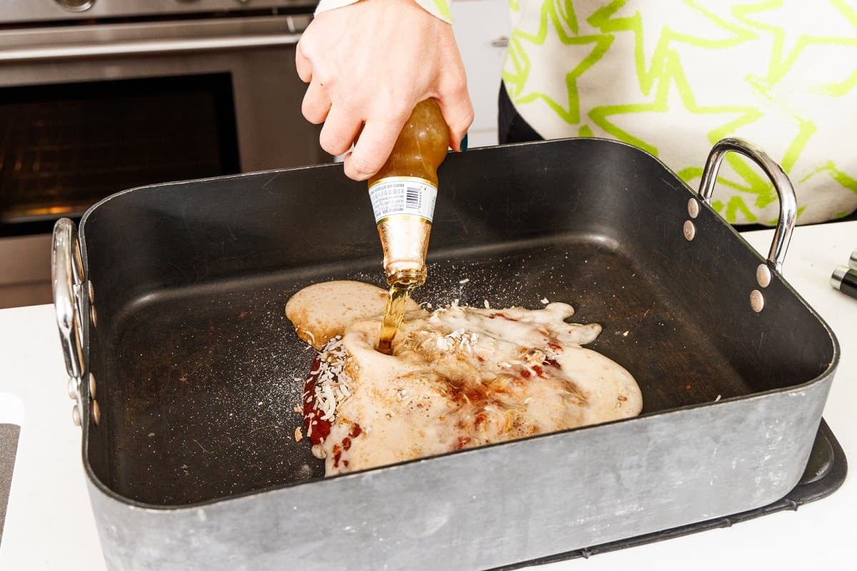 Pouring beef into roasting pan with soup mix and chili sauce.