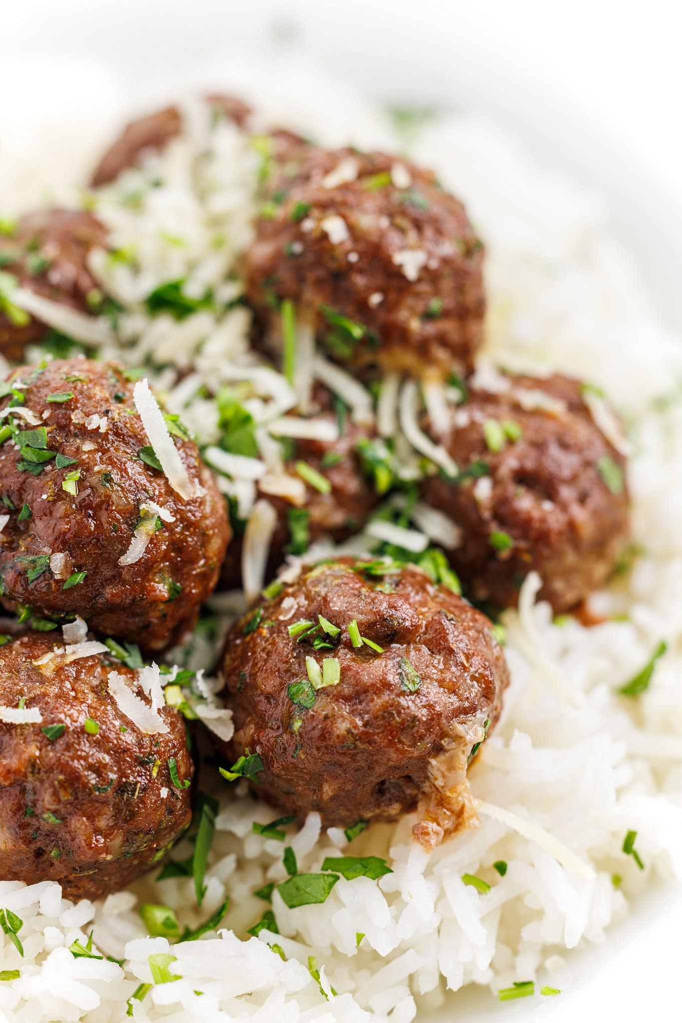 Keftedes (baked greek meatballs) on rice pilaf and garnished with cheese.