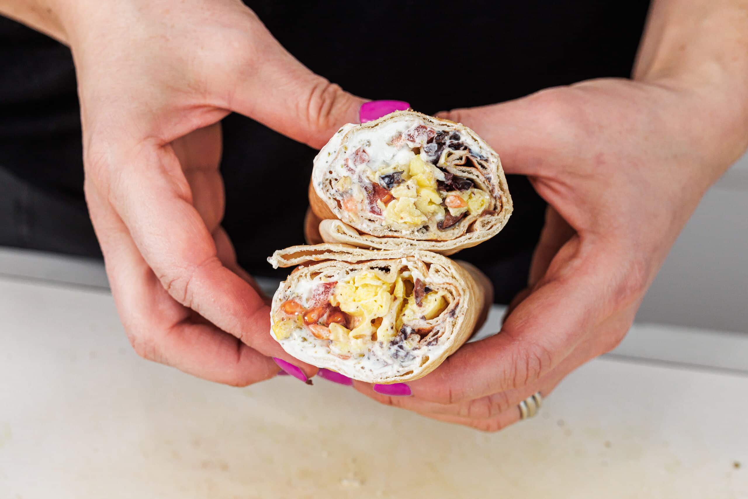 Holding both halves of a Lebanese breakfast pita.