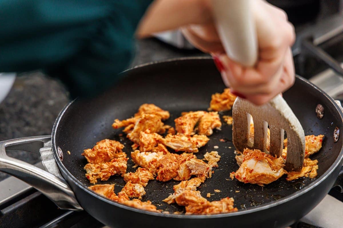 Cooking Hungryroot chicken in a skillet.
