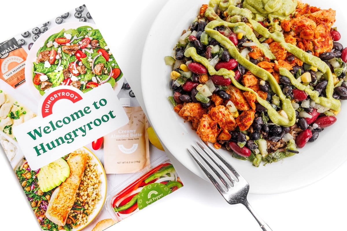 Chicken avocado rice bowl with a fork next to Hungryroot recipe book.
