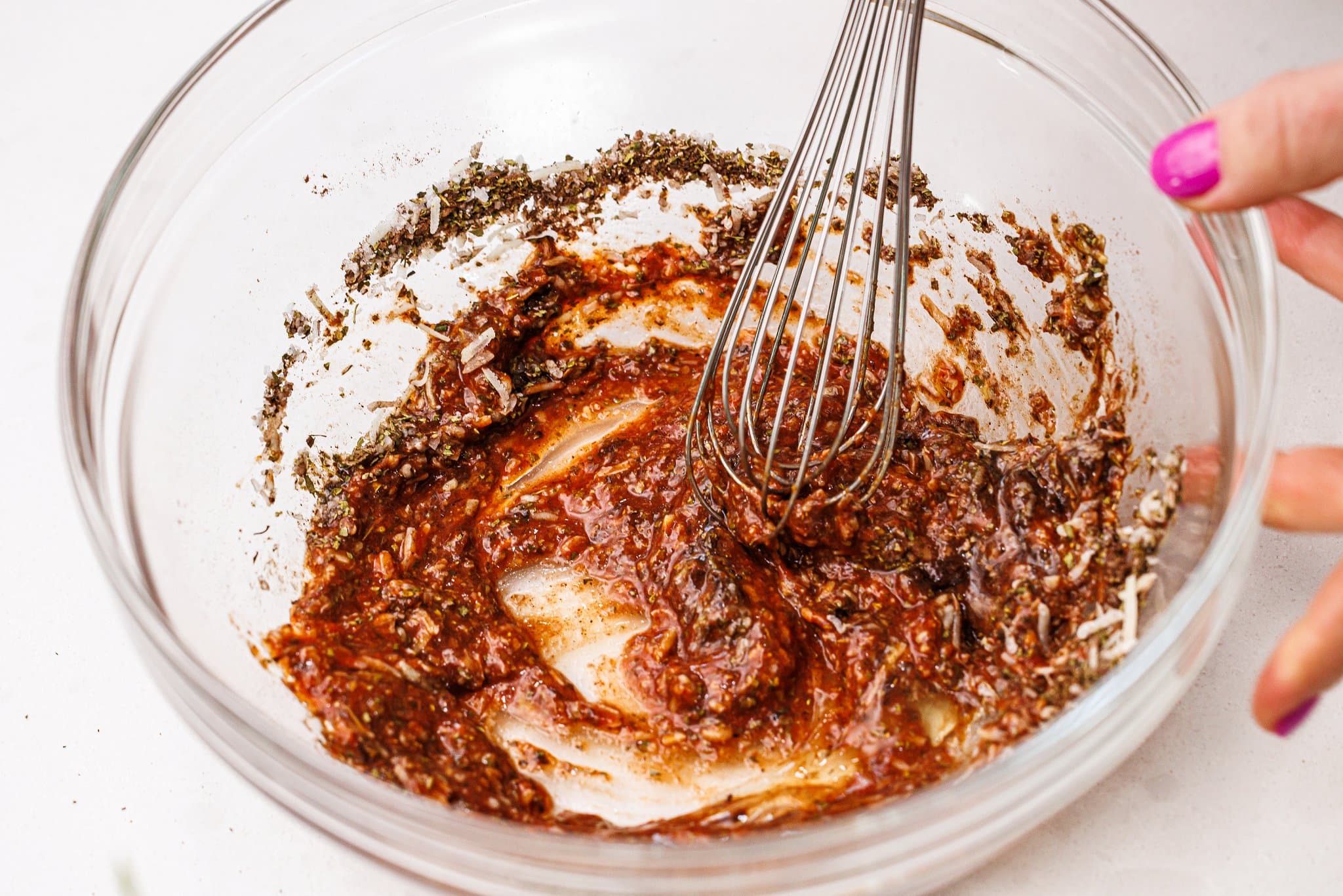 Whisking sauce ingredients for meatballs.