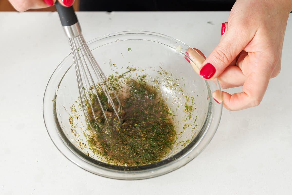 Whisking together lemon vinaigrette.