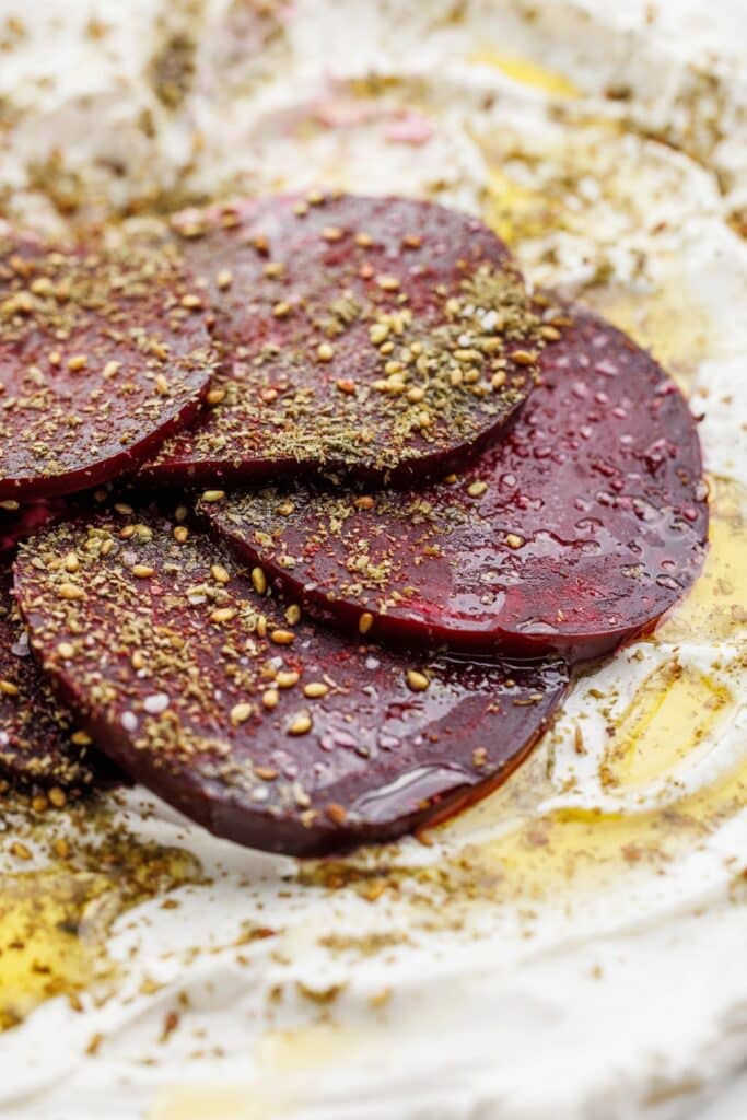 Roasted beet salad with labneh and za'atar sprinkled on top, and drizzled in olive oil.