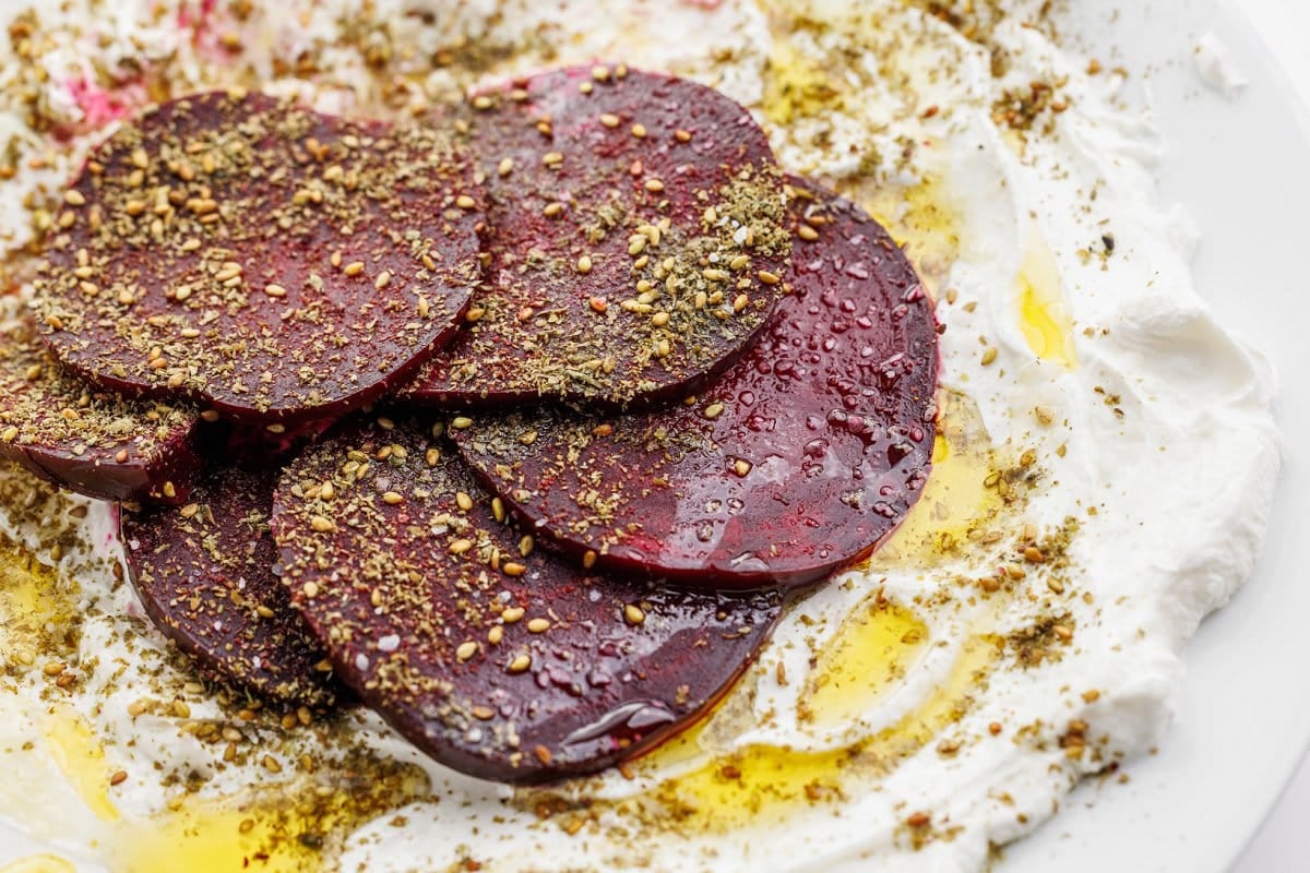 Roasted beet salad with labneh and za'atar spread out on a plate.