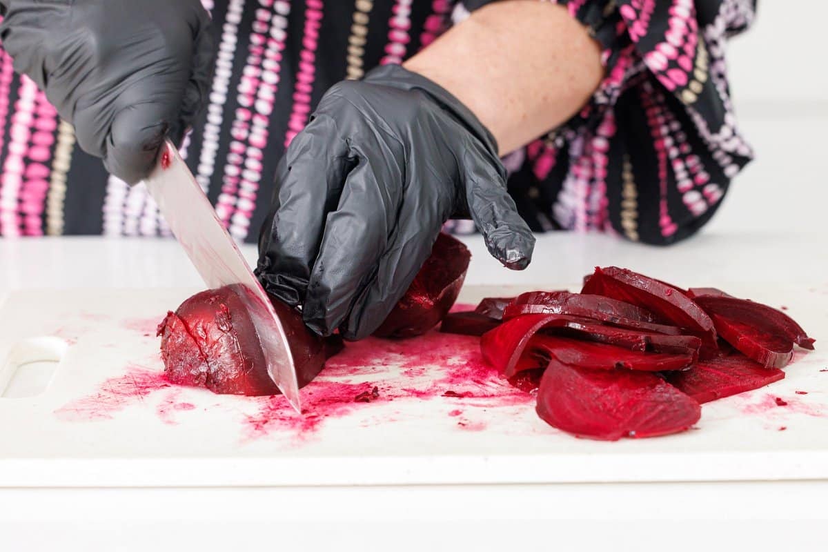 Using a sharp knife to slice roasted beets.