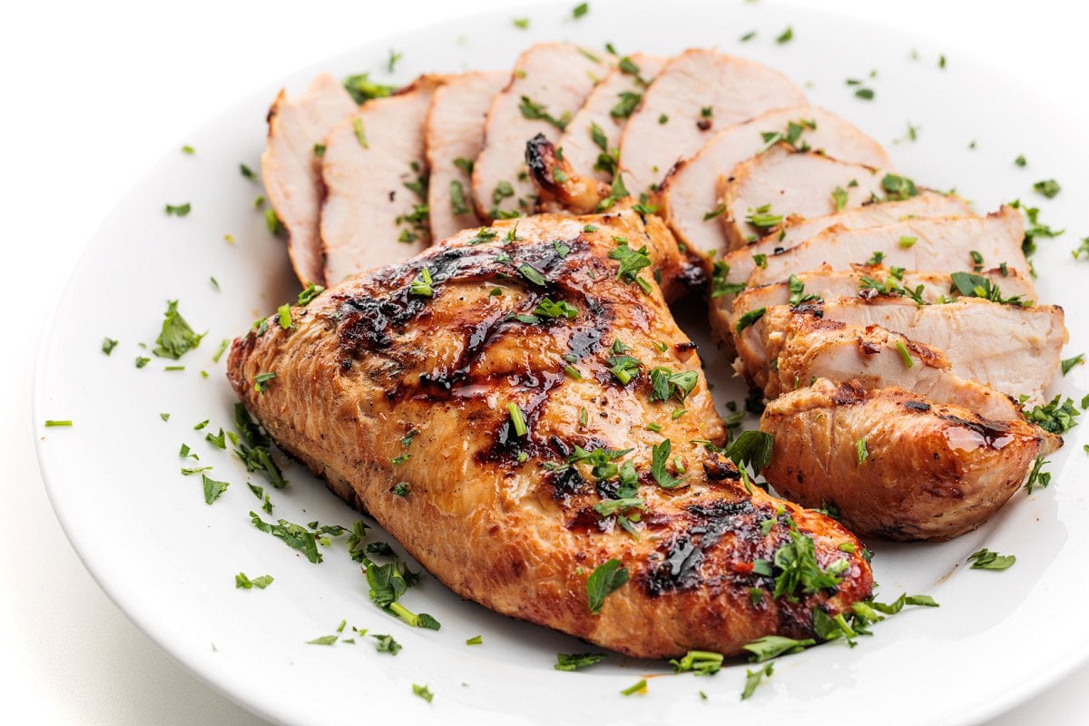 Grilled teriyaki turkey tenderloins on a plate and garnished with parsley.