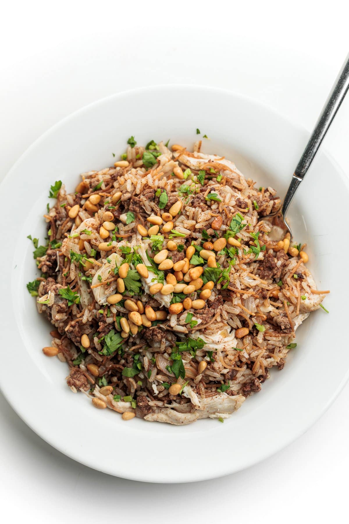 A fork in a large serving of Lebanese Hushwee Rice with Chicken.