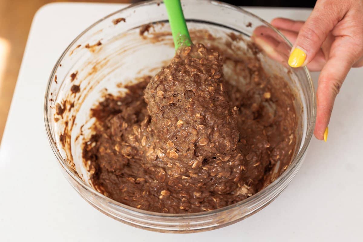 Mixing dry ingredients with wet ingredients for muffins.