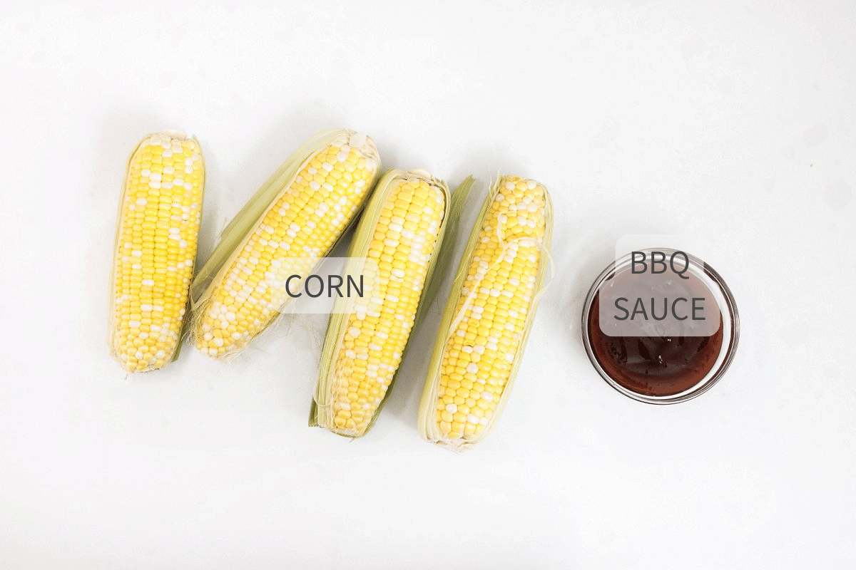 Labeled ingredients for grilled corn with bbq sauce on a white surface.