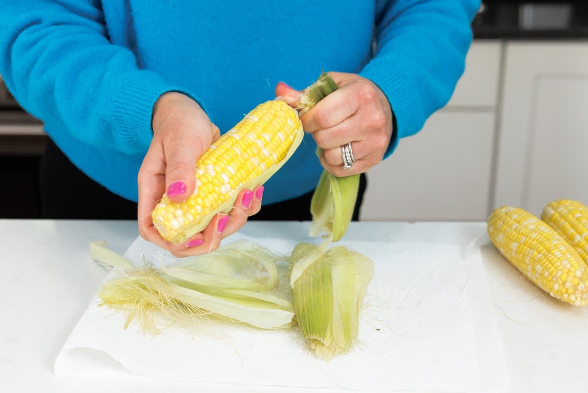 Liz husking corn cobs.