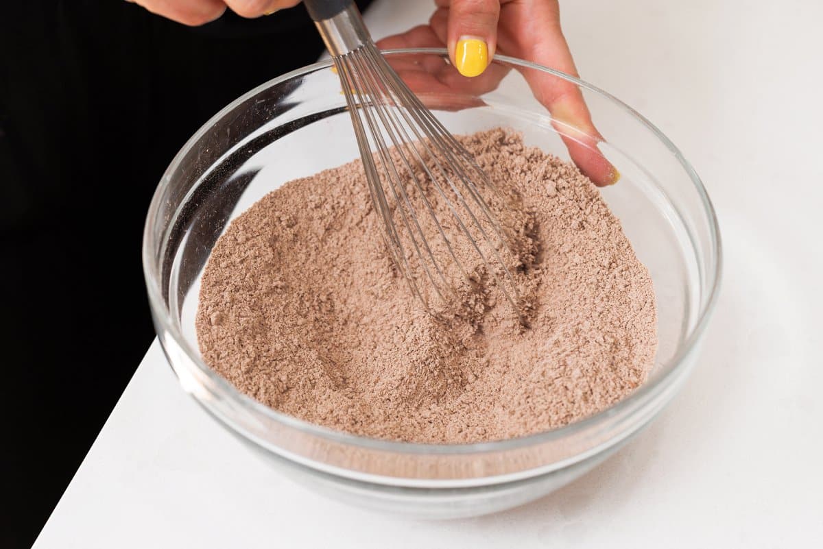 Whisking dry ingredients together in a large bowl.