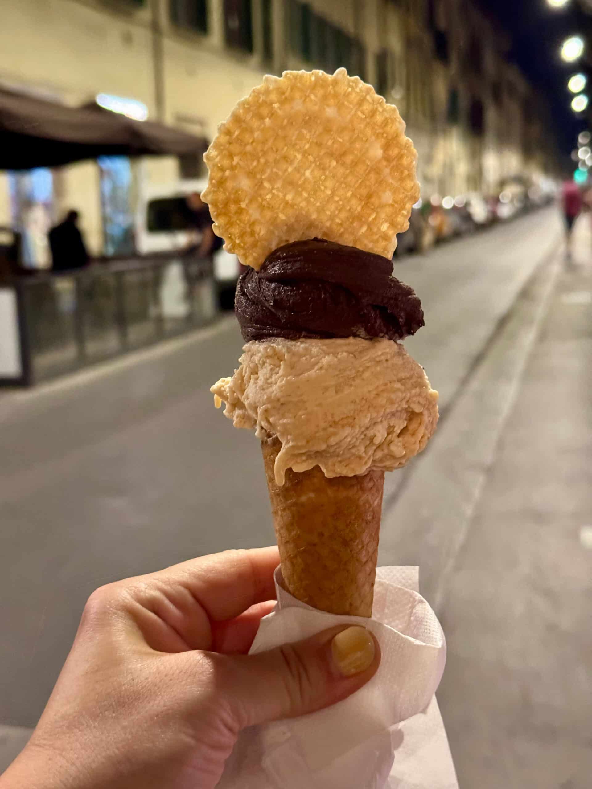 Hand holding gelato on a cone.