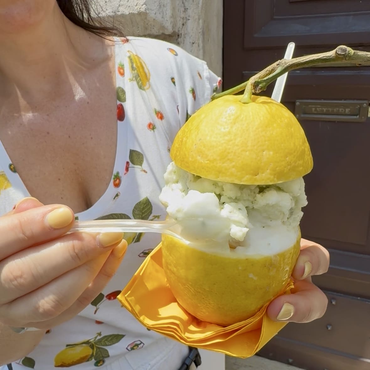 Liz holding lemon sorbet in a hollowed out lemon.