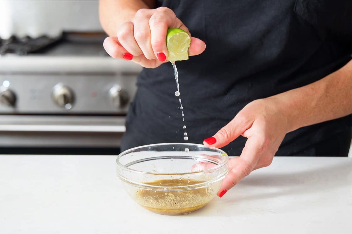 Squeezing fresh lime juice into vinaigrette.