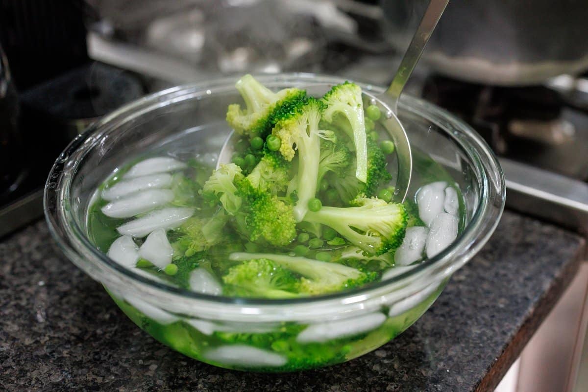 Putting broccoli and peas in ice bath.