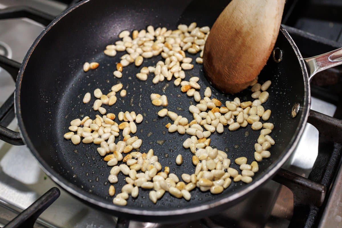 Toasting pine nuts in pan.
