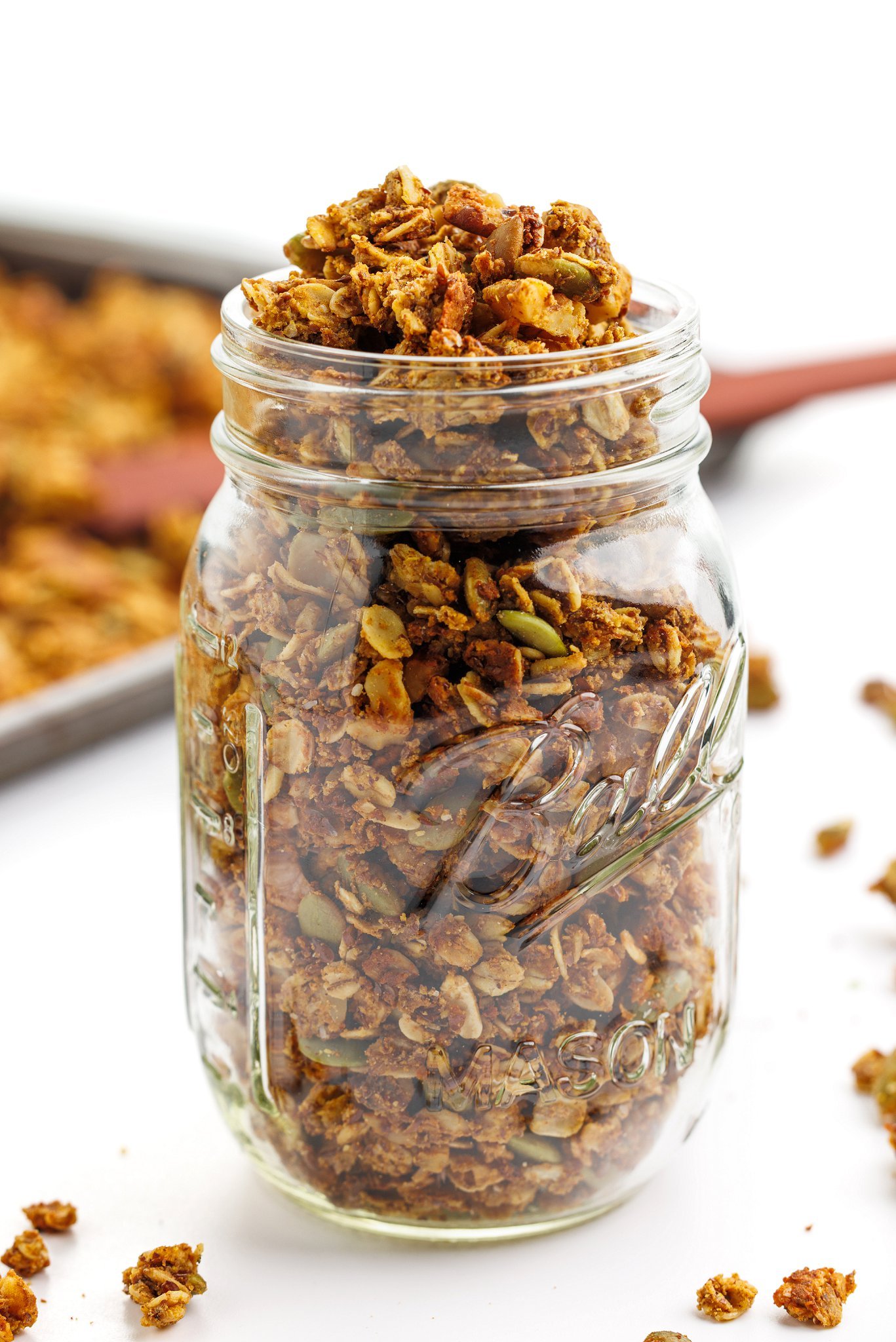 High protein pumpkin spice granola piled high in a mason jar.