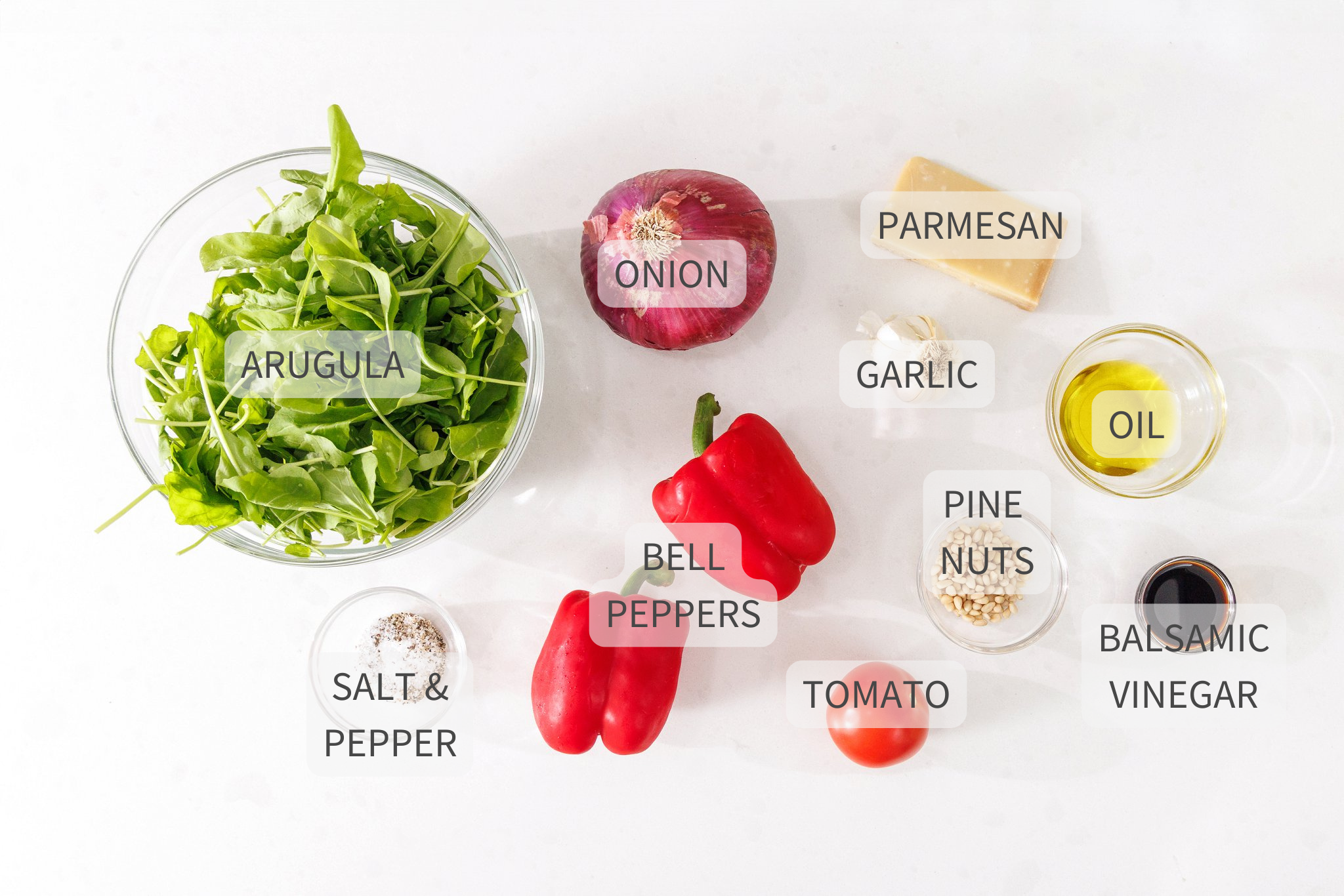 Labeled ingredients for Italian mixed salad on a white counter.