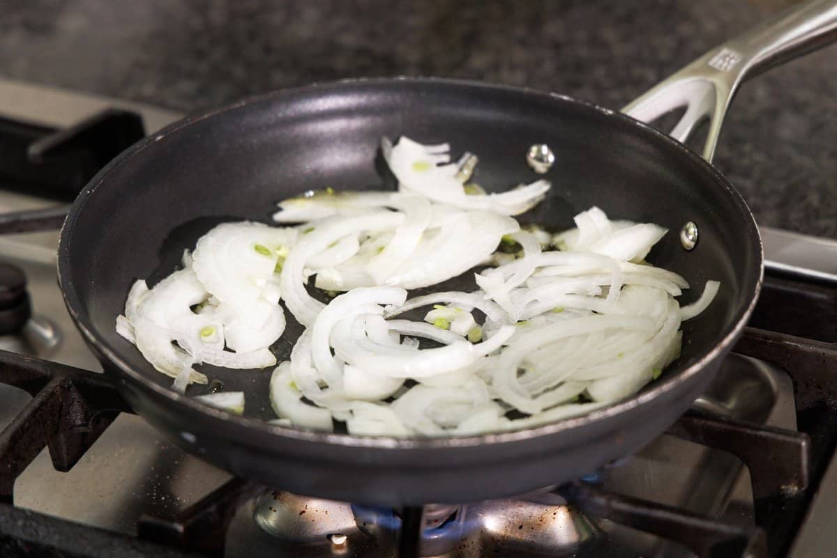 Sliced onions in a sauté pan.