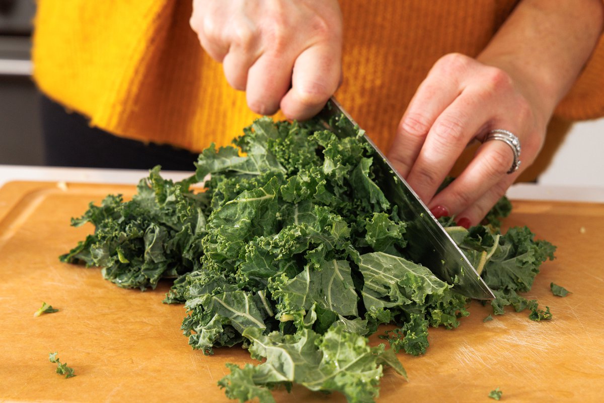 Chopping kale on a cutting board.