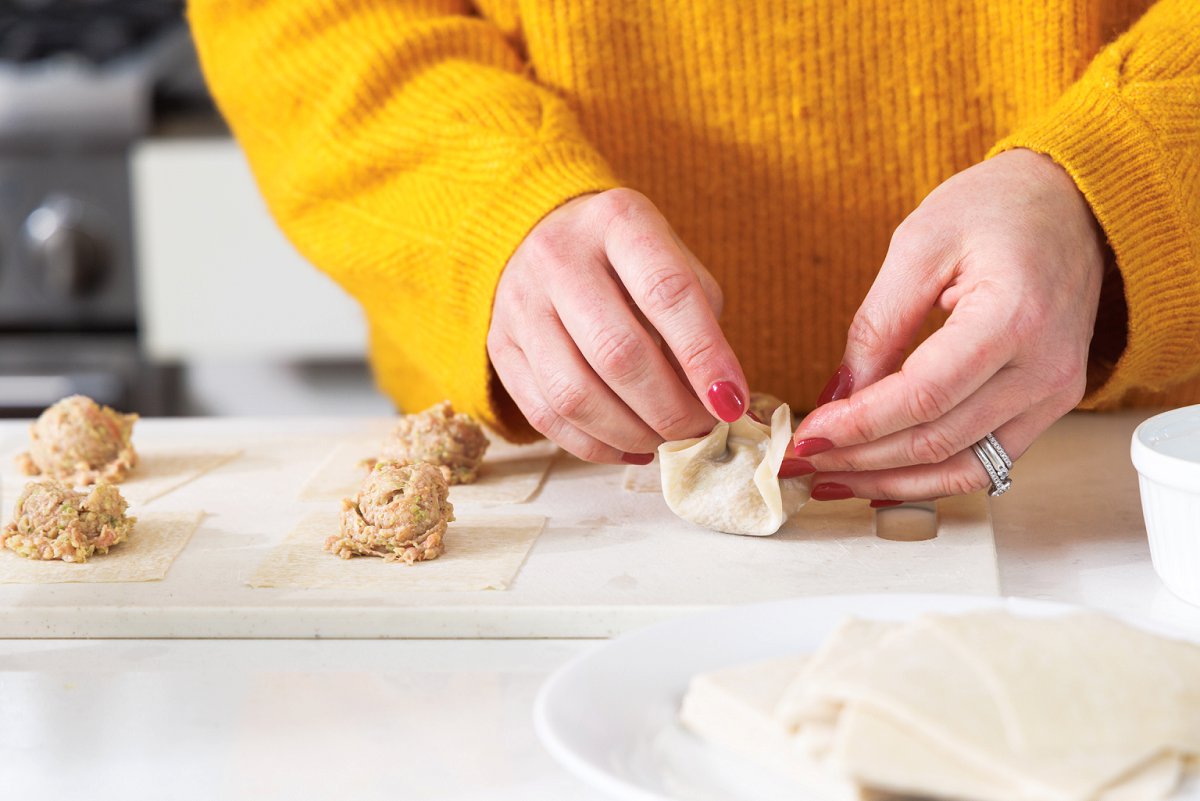 Pinching closed pork dumpling.